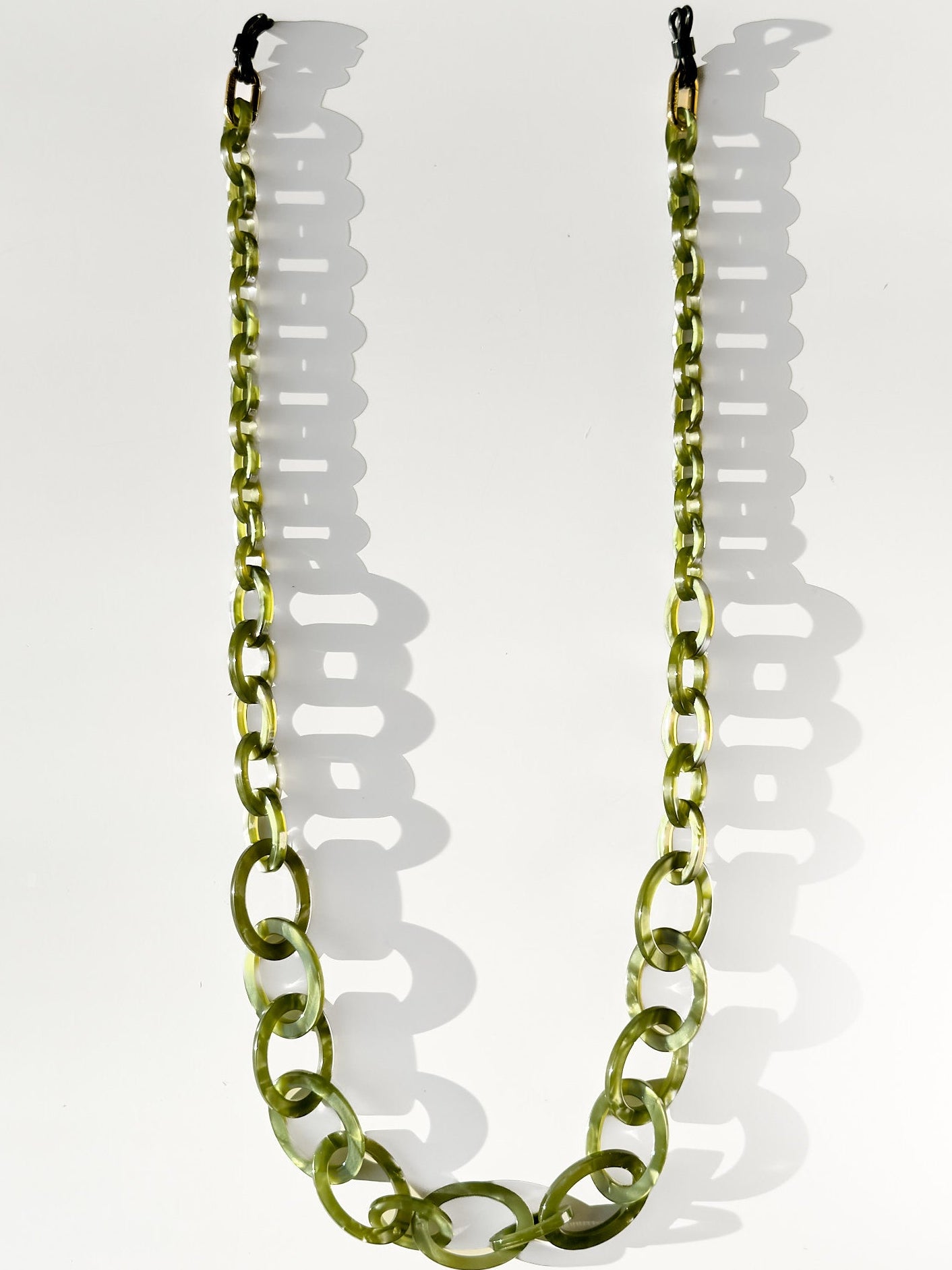 Green glasses chain necklace on a white background
